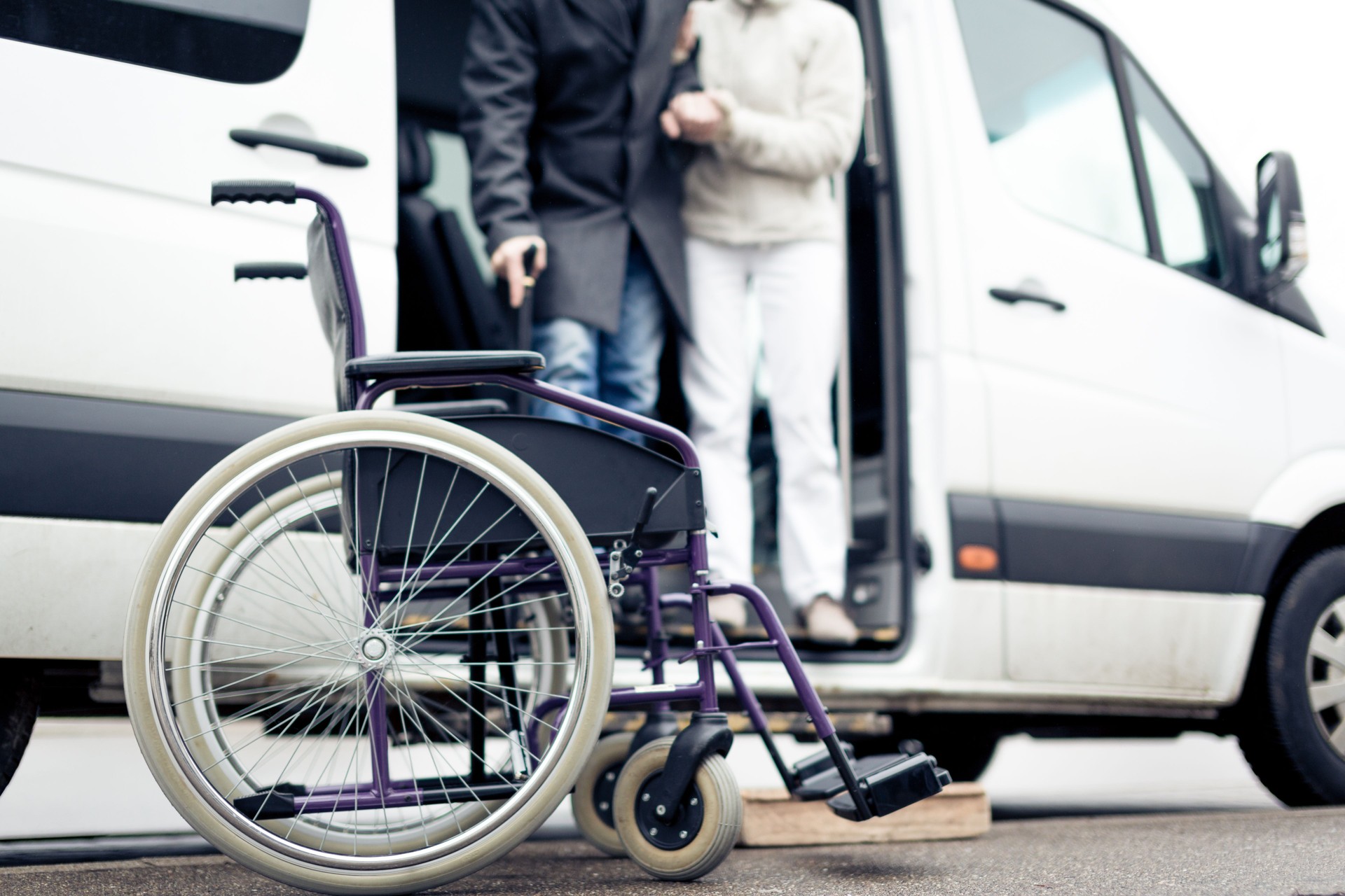 nurse helping senior man exit a van